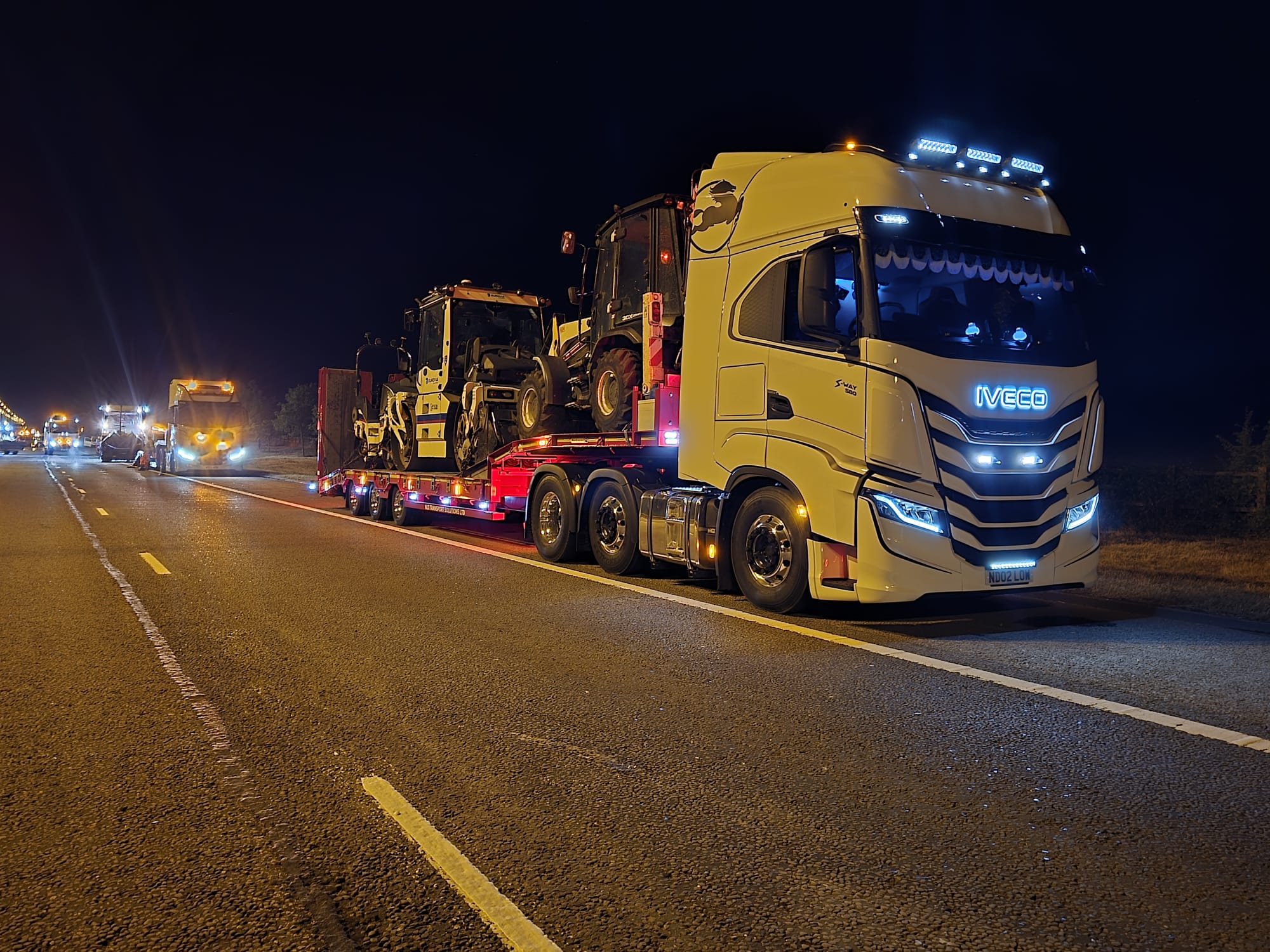 Heavy road-surfacing plant loaded for an overnight relocation