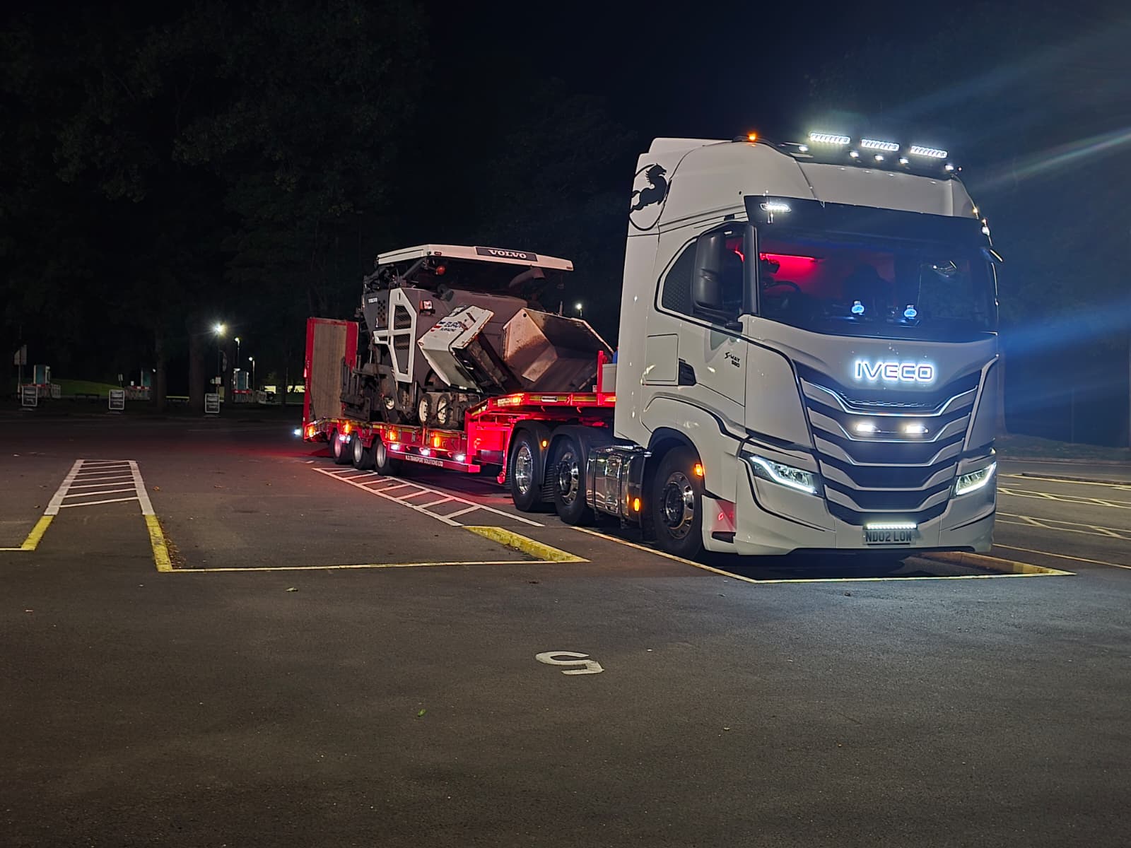 Tractor unit and loaded trailer lit up at night